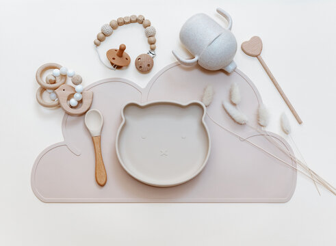 Silicone dishware on light background. Serving baby, first feeding concept. Kids tableware. Flat lay, copy space, top view