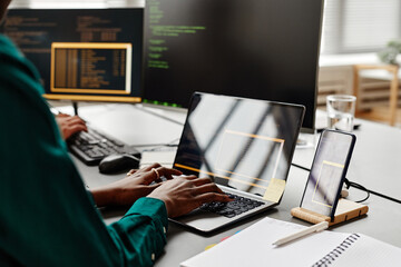 Closeup of female IT developer typing on keyboard while writing code at workplace in office, copy space