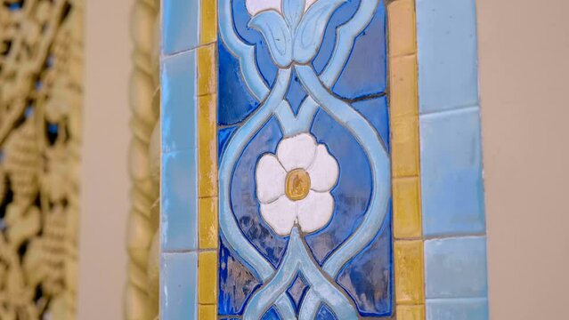 Beautiful colorful ceramic tiles with oriental type floral pattern glisten with voluminous textures and reflect the surroundings. Closeup. Shot in motion