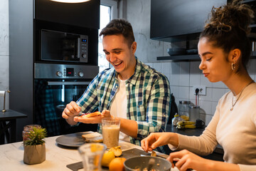 Young couple caucasian man and woman husband and wife or boyfriend and girlfriend brother and sister students preparing breakfast in the kitchen at home real people copy space daily morning routine