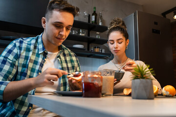 Young couple caucasian man and woman husband and wife or boyfriend and girlfriend brother and sister students preparing breakfast in the kitchen at home real people copy space daily morning routine