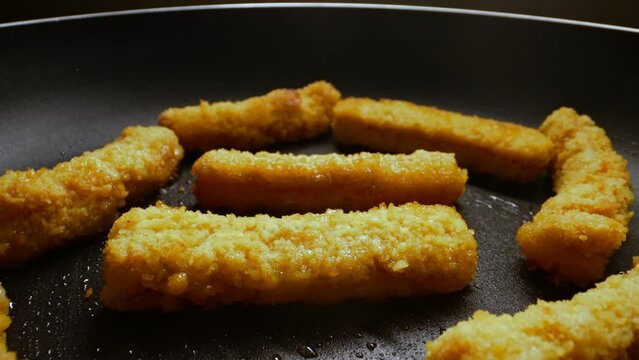 Chicken nuggets frying in a pan.