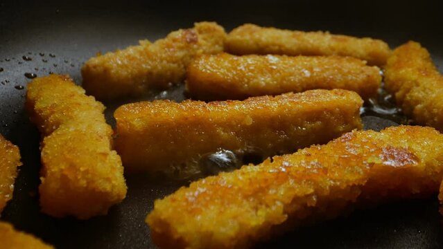 Chicken nuggets frying in a pan.