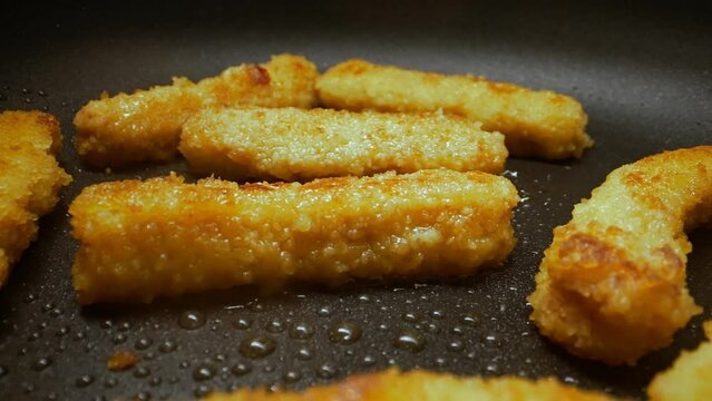 Chicken nuggets frying in a pan.