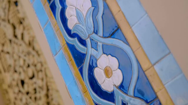 Beautiful colorful ceramic tiles with oriental type floral pattern glisten with voluminous textures and reflect the surroundings. Closeup. Shot in motion