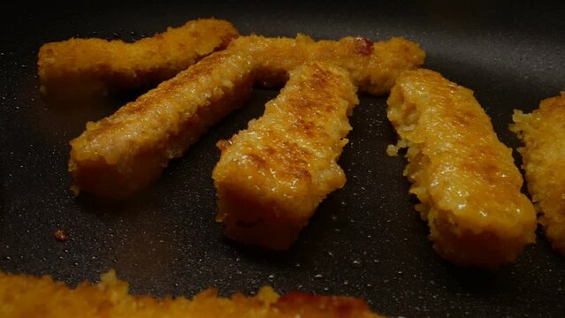 Chicken nuggets frying in a pan.