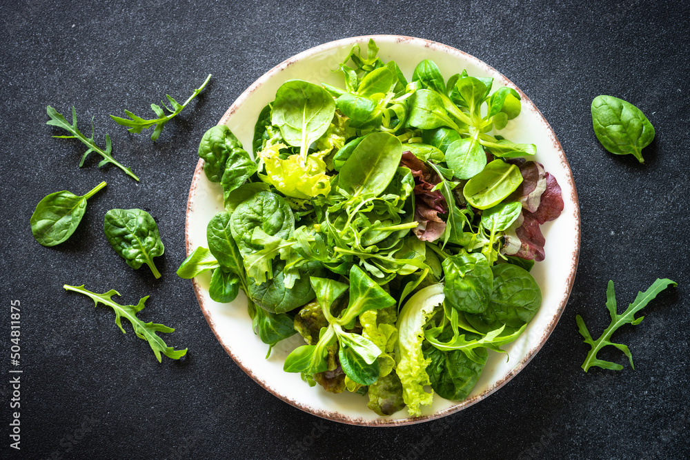 Poster Green salad, Fresh salad leaves and vegetables in white plate.