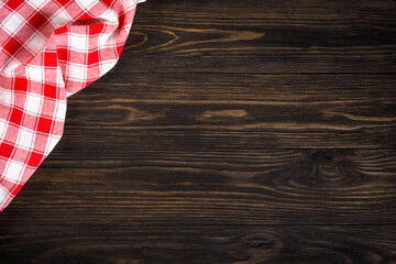 Kitchen table with red plaid tablecloth. Top view copy space on wooden table.