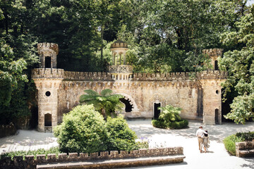 Obraz premium Portal of guardians and walking couple in Quinta da Regaleira in Sintra