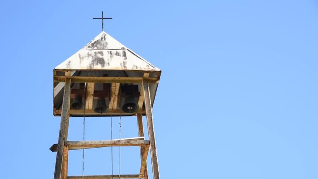 Belfry with three bells and ropes on the blue background