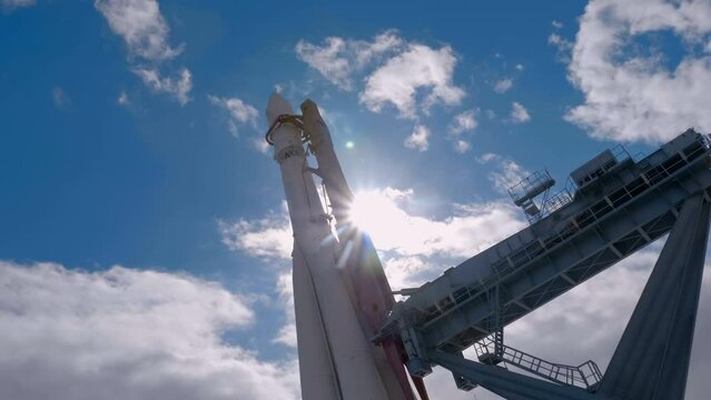 Space rocket at the launch complex against a blue sky with clouds. Shot in motion
