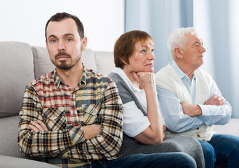 Aged parents arguing with their adult son at home