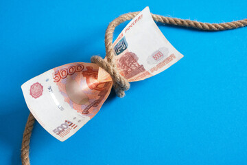 banknote of 5000 rubles and a rope tied in a knot, ruble crisis, ruble restriction, sanctions...