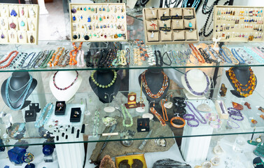 View of window of jewelry store offering various adornments from natural gemstones for sale
