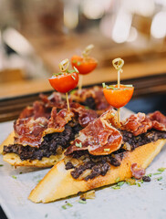 Un canape de jamon curado español y cebolla caramelizada