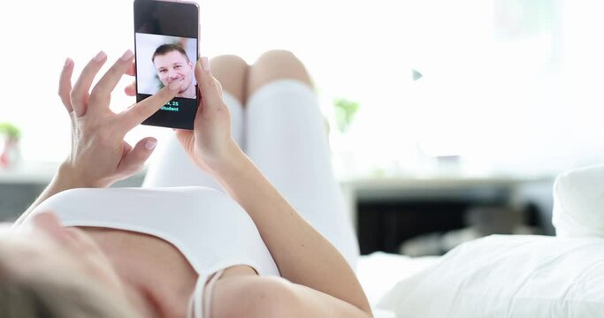 Woman looks at screen of smartphone different profiles of men for dating