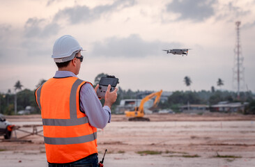 Surveyor engineer wearing safety uniform ,helmet and radio communication with equipment theodolite...