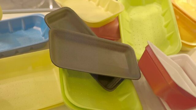 Samples of new different colors of cardboard trays, boxes to single use for food and other uses. Closeup. Shot in motion
