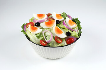 Mixed Vegetable salad with boiled eggs in a bowl. Healthy green salad with boiled eggs and vegetables isolated on white background. Sliced boiled eggs. Healthy food. Hydroponics vegetables.