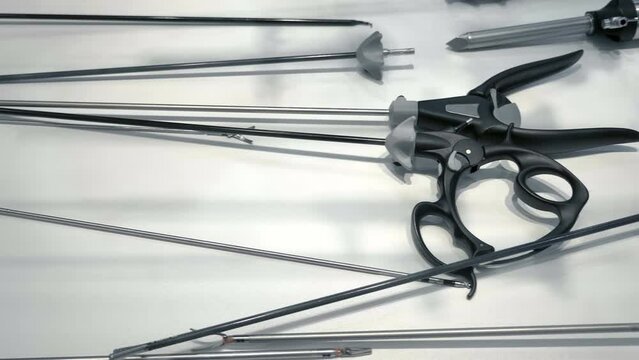 New samples of medical bipolar laparoscopic  clamp (scissors) of various types and purposes at the exhibition of medical innovations. Closeup. Shot in motion