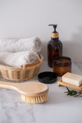 Obraz na płótnie Canvas Massage wooden body brush on the background of spa items. Homemade body care. Dry lymphatic drainage massage and spa treatments. Cactus bristle brush