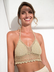 Elegant caucasian model portrait wearing summer golden crochet top