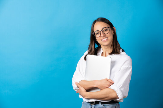 Pretty Hispanic Woman Holding Laptop And Looking At Camera Isolated On Blue Background. Happy Businesswoman Smiling