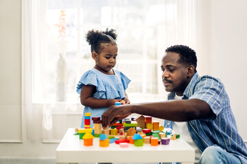 Portrait of happy love black family african american father with little girl smiling activity learn and skill brain training play with toy build wooden blocks board education game at home.father day