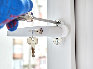 An employee installs a child-safe window handle.