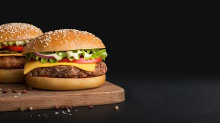 burgers on kitchen board and black background