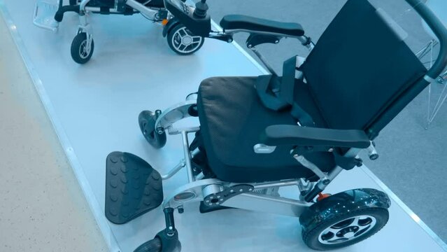 New samples of modern comfortable wheelchairs for the disabled at the exhibition. Closeup. Shot in motion