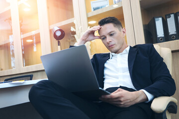 Smart Executive Caucasian businessman looking a laptop computer while working in individual office