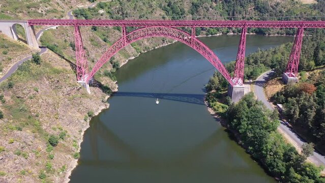 Scenic drone view of parabolic arched framework of railway bridge Viaduc de Garabit across river Truyere near Ruynes-en-Margeride in Auvergne, France