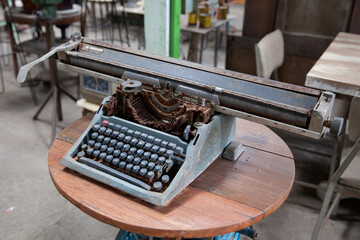Old retro typewriter on table. Ancient printing technique in the closet.