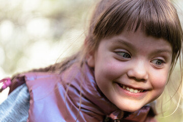 Portrait of smiling cute little girl close-up outdoors.