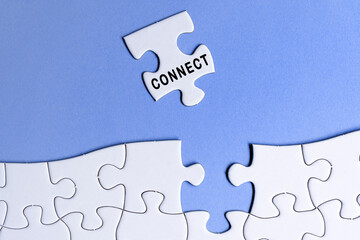 White jigsaw puzzle with word connect over blue background.