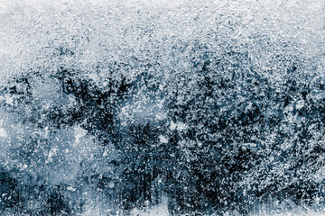 Naklejka na ściany i meble Ice texture background. The textured cold frosty surface of ice block on dark background.