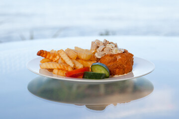 Appetizing dish with French fries and kebab. Potatoes and meat ready to eat on a plate. Tasty food.