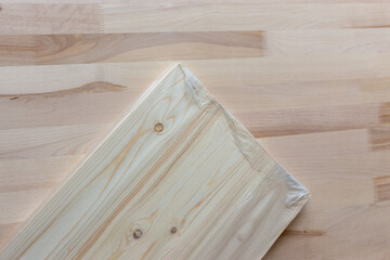 Furniture board in cellophane packaging on a wooden background. Wooden plank.