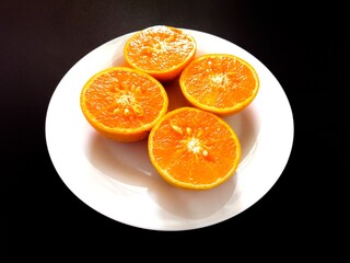 The halved oranges are placed on a plate.