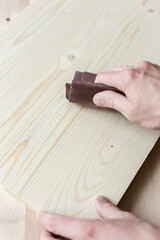 Sanding boards by hand. Sanding with abrasive paper.