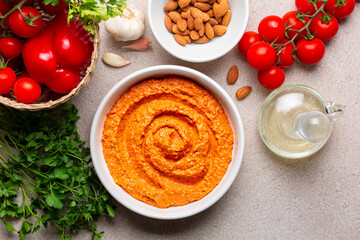 Salsa Romesco and ingredients. Tomato-based Spanish vegetable sauce. Made from mixture of roasted tomatoes, roasted red bell peppers and garlic, toasted almonds, olive oil and bread. Directly above. - obrazy, fototapety, plakaty