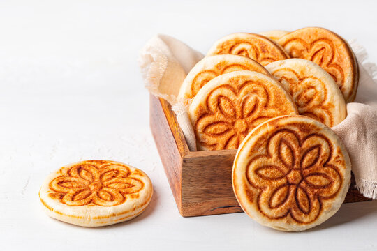 Tigelle or Crescentine, crescente. Thin round breads from the Emilia-Romagna, Northern Italy. They are made from flour, water, salt, and yeast. Selective focus. White table surface.