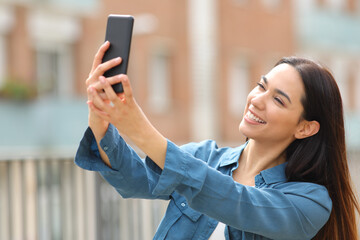 Fototapeta premium Happy woman taking selfie with smart phone