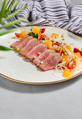 Healthy salad with duck meat, orange and vegetables. Chinese food - duck salad with citrus and fresh dressing. Sliced duck meat with crispy vegetables and pine nuts.