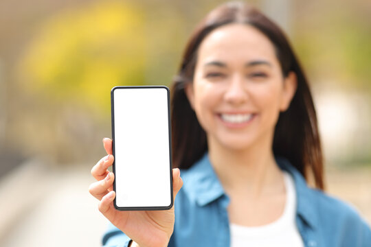 Happy woman showing smart phone screen at camera