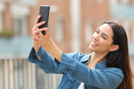 Happy woman taking selfie with smart phone