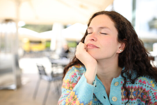 Relaxed woman in a bar resting with closed eyes