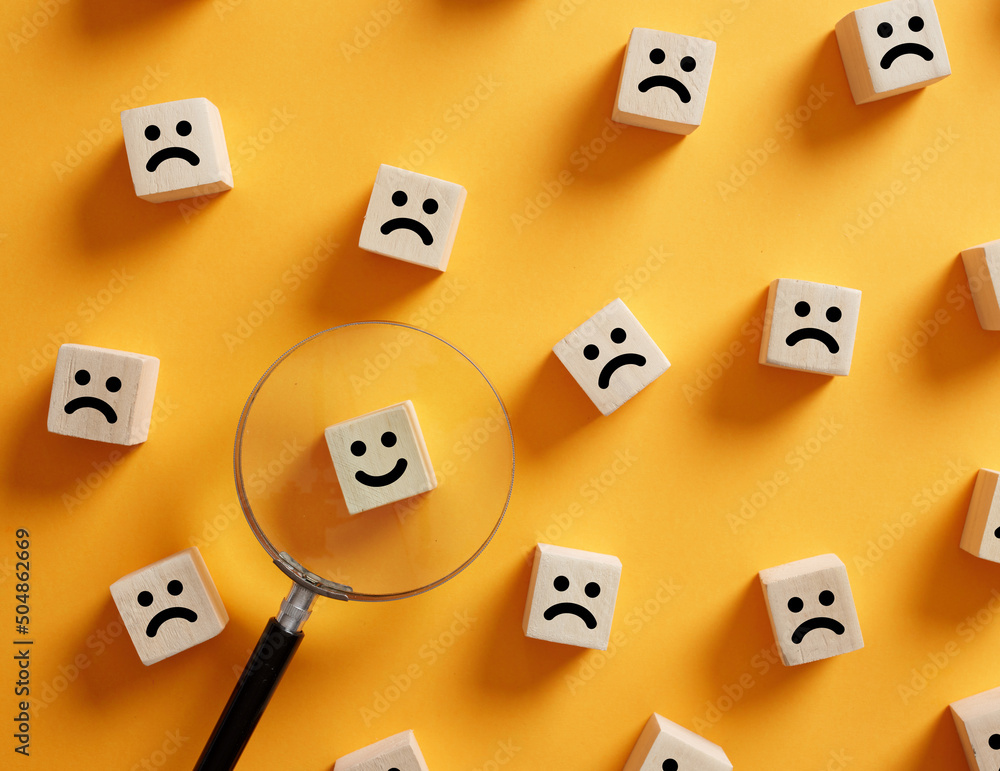 Poster hand holds a magnifier over the smiling happy face symbol. customer satisfaction or searching for a 