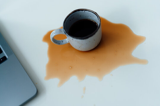 Spilled Coffee By Laptop On Desk